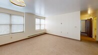 This 650 square foot apartment in Utica, NY offers a practical living space with two bedrooms and one bathroom. The primary bedroom is generously sized at 140 square feet, providing ample space for comfort. The layout is efficiently designed, with a hallway connecting the various rooms.

The apartment features neutral-toned walls and carpeting throughout, creating a bright and airy atmosphere. Large windows in the bedrooms allow natural light to flood the space, enhancing the overall ambiance. The rooms are equipped with baseboard heating units, ensuring comfort during colder months.

The bathroom is modern and functional, with a single vanity, toilet, and a combination tub/shower. It includes ample storage space with built-in cabinets. The kitchen, while not pictured in detail, appears to have basic amenities.

The apartment's design emphasizes simplicity and functionality, with clean lines and minimal ornamentation. This no-frills approach makes it an ideal canvas for personal decorating styles. The uniform flooring and wall treatments throughout create a cohesive look, tying the different spaces together seamlessly.

Located on South Street in Utica, this apartment offers a convenient urban living experience. Its compact yet well-organized layout makes efficient use of the available space, suitable for individuals or small families seeking a comfortable living arrangement in the heart of the city.
