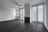 Located in the heart of Los Angeles' Westwood neighborhood, this single-floor residence at 527 Midvale Ave offers a thoughtfully designed layout with modern finishes throughout. The living area is a welcoming, light-filled space featuring rich hardwood-style flooring, crown molding, and a classic fireplace as a focal point. French doors allow generous natural light to pour in while providing views of the surrounding neighborhood, and a ceiling fan adds to the comfort of the space.

The kitchen is well-appointed with contemporary wood cabinetry in warm tones, stainless steel appliances including a gas range, built-in microwave, and refrigerator, complemented by a tiled backsplash and sleek light-colored countertops. A pass-through counter connects the kitchen to the living and dining area, creating an open, functional flow ideal for everyday living and entertaining.

The bathroom features a clean, all-white tub and surround with chrome fixtures, maintaining a bright and minimalist aesthetic. Consistent hardwood-style flooring runs throughout the main living spaces, tying the home together with a cohesive, modern look. The overall ambiance is bright, clean, and move-in ready, offering a comfortable urban retreat in one of Los Angeles' most sought-after neighborhoods.