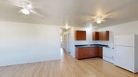 Located at 29456 Old Portland Rd in Adel, Iowa, this single-story, three-bedroom, one-bathroom home offers a practical and well-organized layout. The open-concept kitchen and living area serves as the heart of the home, featuring light wood-style flooring, ceiling fans, and baseboard heating throughout. The kitchen is equipped with warm-toned wood cabinetry, dark countertops, a double sink, a white electric range, and a full-size refrigerator, providing ample functionality for everyday living. The living room benefits from natural light through a large window overlooking the neighborhood, with two exterior doors offering convenient access. Each of the three bedrooms is carpeted and finished with neutral tones, creating a clean and versatile environment. The bedrooms feature windows that bring in natural light, with views of the surrounding landscape and neighboring properties. Ceiling fans in select bedrooms add comfort year-round. The bathroom is straightforward with a toilet and baseboard heat. A dedicated utility room rounds out the interior. The overall ambiance is clean, bright, and move-in ready, making this home a functional option in the Adel, Iowa community.