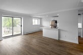 Located at 38 King St W in Hamilton, Ontario, this 2-bedroom, 1-bathroom unit offers a thoughtfully laid-out single-floor plan. The renovated galley kitchen is a standout feature, showcasing crisp white shaker-style cabinetry extending to the ceiling, quartz countertops, a subway tile backsplash, and a full suite of stainless steel appliances including a refrigerator, electric range, and over-the-range microwave. Light-toned hardwood-style flooring runs throughout the entire unit, lending a clean and cohesive aesthetic. The living room is bright and airy, highlighted by a large sliding glass door that opens to a balcony with outdoor views, and is equipped with a wall-mounted mini-split unit for climate control. Both bedrooms are comfortably sized with natural light from windows, baseboard heating, and neutral wall tones. The primary bedroom also includes a mini-split unit for added comfort. The bathroom features a full soaker tub and shower combination with classic white subway tile surround and chrome fixtures. Two hallways connect the spaces efficiently, completing this well-organized and move-in-ready unit in a convenient Hamilton location.