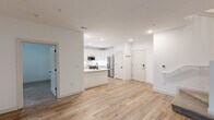 Located at 401 Oberlin Rd in Raleigh, NC, this thoughtfully designed two-story home offers three bedrooms, three bathrooms, and a bright, contemporary aesthetic throughout. The main floor features an open-concept living and kitchen area bathed in natural light, with light wood-tone flooring that flows seamlessly from room to room. The kitchen is a standout, boasting white shaker cabinetry, a quartz waterfall island with an undermount sink and matte black faucet, a white tile backsplash, and a full suite of stainless steel appliances including a refrigerator, range, and built-in microwave. A convenient half bath with white cabinetry and black hardware accents is also located on the main level. The staircase leads to the upper floor, where the bedrooms are carpeted for comfort and fitted with ceiling fans and double-pane windows that invite natural light and outdoor views. The primary bedroom is generously sized and includes a walk-in closet with wire shelving. The bathrooms are elegantly finished with white vanities, quartz countertops, and matte black fixtures, with the primary bath featuring a dual-sink vanity and contemporary globe lighting. Each closet offers dedicated wire-rack storage throughout.