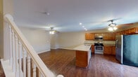 This three-floor home offers a thoughtfully designed layout with a blend of practical finishes and comfortable living spaces throughout. The main level features an open-concept kitchen and living area, unified by rich hardwood-style flooring. The kitchen is well-equipped with warm honey-toned cabinetry, granite countertops, a peninsula with a double stainless steel sink, and a full suite of stainless steel appliances including an electric range, over-the-range microwave, dishwasher, and refrigerator. Recessed lighting and a ceiling fan keep the combined living space bright and comfortable.

The upper level hosts generously sized bedrooms, each finished with plush carpeting, ceiling fans with lighting, and ample natural light from windows. Bedrooms include closets, providing practical storage. The bathrooms are finished with tile flooring, warm wood vanities, and clean white fixtures. One bathroom features a walk-in shower stall, while another serves as a convenient half bath.

The lower level includes a large carpeted bonus room or additional bedroom with ceiling fan and recessed lighting, offering flexible use as a recreation room or home office. The attached two-car garage provides direct interior access and is equipped with an automatic opener, completing this functional multi-level home.