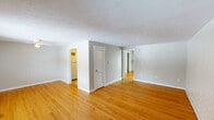 Located at 145 Pinney St in Ellington, CT, this single-floor, one-bedroom, one-bathroom unit offers a well-organized and efficient layout. Warm hardwood floors run throughout the main living areas, complemented by textured ceilings and neutral gray and white walls that create a clean, bright atmosphere. The living room is an inviting space anchored by a sliding glass door that floods the room with natural light and provides views of the surrounding outdoor scenery. A painted brick accent wall and baseboard heating add character and practicality. The entry foyer features a classic paneled door with a transom window, welcoming residents into the space. The kitchen is equipped with white cabinetry, granite-style countertops, a tile backsplash, and white appliances including a refrigerator and electric range, offering a functional and tidy cooking space. The bedroom is a comfortable, well-proportioned room with hardwood flooring, a ceiling fan, and a window that brings in natural light. A dedicated closet provides convenient storage. The bathroom features a full tub-shower combination with white subway tile, a decorative mosaic accent border, and a vanity with sink. This unit offers a practical and comfortable living environment in a residential Ellington neighborhood.
