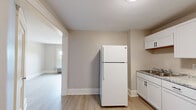 Located at 1101 Elm St in Manchester, New Hampshire, this one-bedroom, one-bathroom residence offers a thoughtfully designed single-floor layout with clean, updated finishes throughout. Light wood-tone flooring runs consistently across the entire space, creating a cohesive and airy feel that unifies each room.

The kitchen is equipped with white cabinetry, a granite-style countertop, a white gas range, and a full-size refrigerator, providing a functional and well-appointed cooking area. The open sightline from the kitchen into the living area enhances the sense of space within the compact footprint.

The bedroom is generously sized relative to the overall floor plan, featuring neutral warm-gray walls, crisp white baseboard trim, and a window with a radiator beneath it that allows for natural light and traditional heating. A closet with double doors provides practical storage directly off the entry area.

The bathroom includes a full-size soaking tub with a tiled surround and a window that brings in natural light, maintaining the bright and clean aesthetic found throughout the residence. The entryway features a modern keypad-entry door alongside a double-door closet, adding both security and convenience. Overall, the space presents a fresh, neutral palette ideal for easy personalization.