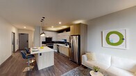 Located in the heart of Chicago's Loop at 29 S La Salle Street, Unit 311 is a well-appointed one-bedroom, one-bathroom apartment offering a thoughtfully designed open-concept layout. Dark hardwood floors run throughout the main living areas, anchoring the contemporary aesthetic and creating a cohesive flow between spaces.

The kitchen is a standout feature, showcasing a striking combination of white upper cabinetry and warm wood-toned lower cabinets, complemented by a bold dark chevron-patterned tile backsplash. Stainless steel appliances, including a gas range, dishwasher, microwave, and French door refrigerator, add a sleek, professional finish. A kitchen island with a white quartz countertop and pendant lighting serves as both a prep space and casual dining area with bar seating.

The living area is open and bright, with large windows allowing natural light and city views. The bedroom features plush carpeting, large windows with urban views, and direct access to a spacious walk-in closet with built-in shelving.

The bathroom is clean and modern, with large-format tile flooring, a floating wood-toned vanity with a rectangular mirror, and a tiled shower/tub combination. The overall design of the unit reflects a refined urban sensibility, balancing functionality with contemporary style throughout.