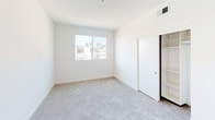 Located at 1446 Tamarind Ave in the heart of Hollywood, Los Angeles, this single-floor unit offers a clean, modern aesthetic throughout. The open-concept kitchen is a standout feature, outfitted with warm wood-toned cabinetry, stainless steel appliances including a gas range, microwave, refrigerator, and dishwasher, along with a peninsula with a built-in sink and light quartz countertops. Light hardwood-style flooring runs through the kitchen and main living areas, lending warmth and continuity to the space. The bedrooms are carpeted for comfort and feature sliding or hinged closets with built-in shelving, providing ample storage. Large windows in the bedrooms invite natural light and offer views of the surrounding Hollywood neighborhood, including glimpses of palm trees and the LA skyline. The bathrooms are finished to a high standard, featuring wood-grain vanity cabinets, backlit mirrors, quartz countertops, and large-format tile flooring. One bathroom includes a tub and shower combo enclosed in sliding glass doors with striking marble-style tile surround. A recessed electrical panel is conveniently located in one of the utility areas. The overall design is bright, contemporary, and move-in ready, reflecting the modern urban character of its Hollywood location.