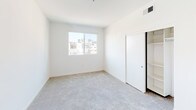 Located at 1446 Tamarind Ave in the heart of Hollywood, Los Angeles, this single-floor unit offers a clean, modern aesthetic throughout. The open-concept kitchen is a standout feature, outfitted with warm wood-toned cabinetry, stainless steel appliances including a gas range, microwave, refrigerator, and dishwasher, along with a peninsula with a built-in sink and light quartz countertops. Light hardwood-style flooring runs through the kitchen and main living areas, lending warmth and continuity to the space. The bedrooms are carpeted for comfort and feature sliding or hinged closets with built-in shelving, providing ample storage. Large windows in the bedrooms invite natural light and offer views of the surrounding Hollywood neighborhood, including glimpses of palm trees and the LA skyline. The bathrooms are finished to a high standard, featuring wood-grain vanity cabinets, backlit mirrors, quartz countertops, and large-format tile flooring. One bathroom includes a tub and shower combo enclosed in sliding glass doors with striking marble-style tile surround. A recessed electrical panel is conveniently located in one of the utility areas. The overall design is bright, contemporary, and move-in ready, reflecting the modern urban character of its Hollywood location.