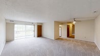 Located at 27025 Oakwood Cir in Olmsted Falls, Ohio, this two-bedroom, two-bathroom single-floor residence offers a practical and well-organized layout. The combined living and dining area is generously sized, featuring neutral carpet flooring, a ceiling fan with light fixture, and a sliding glass door that opens to an outdoor balcony, allowing natural light to fill the space. An entry door with adjacent wall panel provides a welcoming foyer transition into the main living area.

The kitchen is equipped with white cabinetry featuring warm wood trim, dark laminate countertops, a double-basin sink, and a full suite of white appliances including a gas range, dishwasher, and refrigerator. Light hardwood-style flooring and a window overlooking the outdoors complete the functional cooking space.

Both bedrooms are carpeted and receive natural light through windows. The primary bedroom is a comfortable size and includes a double sliding-door closet with wood-paneled doors. The secondary bedroom also offers good proportions and natural light.

The two bathrooms feature vanity sinks with wood-trimmed cabinetry, large mirrors with overhead lighting, and clean, neutral finishes — one with tile-style flooring and one with hardwood-style flooring. A dedicated laundry room and five closets throughout round out this well-appointed residence.