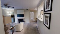 Located in Birmingham, Alabama, this single-floor, three-bedroom, two-bathroom residence offers a well-organized layout designed for comfortable everyday living. The living room serves as the heart of the home, featuring a white tile-surround fireplace, plush carpeting, crown molding, a ceiling fan, and a glass door that opens to a private balcony overlooking lush greenery. The adjacent kitchen is equipped with warm wood cabinetry, stainless steel appliances including a range, microwave, and refrigerator, and a bright white countertop that extends into a convenient pass-through bar. The dedicated dining area is a refined space with crown molding, track lighting, and a tray ceiling detail. A hallway connects the three bedrooms and two bathrooms, maintaining a practical and private sleeping quarters. The primary bedroom offers a comfortable footprint with closet access, soft carpeting, and neutral tones. Both bathrooms are well-equipped, with one featuring warm wood vanity cabinetry, a large framed mirror, and a tub-shower combination. A utility room and additional closet provide ample storage. Throughout, neutral wall tones and carpet flooring create a cohesive and understated aesthetic.