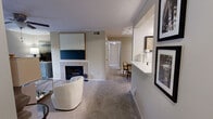 Located in Birmingham, Alabama, this single-floor, three-bedroom, two-bathroom residence offers a well-organized layout designed for comfortable everyday living. The living room serves as the heart of the home, featuring a white tile-surround fireplace, plush carpeting, crown molding, a ceiling fan, and a glass door that opens to a private balcony overlooking lush greenery. The adjacent kitchen is equipped with warm wood cabinetry, stainless steel appliances including a range, microwave, and refrigerator, and a bright white countertop that extends into a convenient pass-through bar. The dedicated dining area is a refined space with crown molding, track lighting, and a tray ceiling detail. A hallway connects the three bedrooms and two bathrooms, maintaining a practical and private sleeping quarters. The primary bedroom offers a comfortable footprint with closet access, soft carpeting, and neutral tones. Both bathrooms are well-equipped, with one featuring warm wood vanity cabinetry, a large framed mirror, and a tub-shower combination. A utility room and additional closet provide ample storage. Throughout, neutral wall tones and carpet flooring create a cohesive and understated aesthetic.