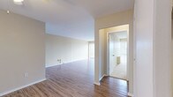 Located at 1930 Noble Rd in East Cleveland, Ohio, this single-floor unit offers a straightforward and functional layout spread across several well-defined living areas. The open living space is one of the unit's most notable features, showcasing wood-style laminate flooring that runs throughout the main areas, neutral warm-toned walls, and a ceiling fan that adds practical comfort. A large sliding glass door fitted with vertical blinds allows abundant natural light to fill the space while providing access to an outdoor view.

The living area connects to a separate room with carpet flooring and its own sliding glass door, also dressed with vertical blinds, offering additional light and an outdoor outlook. This carpeted room includes a built-in closet with bifold doors, making it well-suited as a bedroom.

The kitchen is efficiently arranged in an L-shaped configuration with white cabinetry above and below the counters, a stone-patterned laminate countertop, a stainless steel sink, a white dishwasher, and a white tile backsplash. Wood-style flooring continues into this space, maintaining visual consistency.

The bathroom features white tile walls, a tub and shower combination enclosed by sliding frosted glass doors, a toilet, and a vanity with a mosaic-trimmed countertop and a wall-mounted mirror cabinet above.