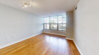Located in the heart of Washington, DC's West End neighborhood, this one-bedroom, one-bathroom residence offers a well-designed layout across a single floor. The open living and dining area is a standout, featuring warm hardwood flooring and a striking wall of floor-to-ceiling windows that frame views of the surrounding cityscape and tree canopies, flooding the space with abundant natural light. A dedicated windowed nook within the living area provides additional versatility and charm.

The kitchen is fully equipped with stainless steel appliances, including a refrigerator, range, microwave, and dishwasher, complemented by warm wood cabinetry, granite countertops, a tile backsplash, and light tile flooring.

The generously sized bedroom features plush carpeting and a large window with views of the urban surroundings, offering a comfortable and private retreat. A hallway connects the bedroom to the full bathroom, which includes a combination tub and shower, a wide vanity with wood cabinetry, a large mirror, and light tile flooring throughout.

The hallway also provides convenient access to both the bathroom and kitchen, creating an efficient and logical flow throughout the residence. This well-appointed home combines functional design with urban convenience in a prime DC location.