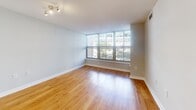Located in the heart of Washington, DC's West End neighborhood, this one-bedroom, one-bathroom residence offers a well-designed layout across a single floor. The open living and dining area is a standout, featuring warm hardwood flooring and a striking wall of floor-to-ceiling windows that frame views of the surrounding cityscape and tree canopies, flooding the space with abundant natural light. A dedicated windowed nook within the living area provides additional versatility and charm.

The kitchen is fully equipped with stainless steel appliances, including a refrigerator, range, microwave, and dishwasher, complemented by warm wood cabinetry, granite countertops, a tile backsplash, and light tile flooring.

The generously sized bedroom features plush carpeting and a large window with views of the urban surroundings, offering a comfortable and private retreat. A hallway connects the bedroom to the full bathroom, which includes a combination tub and shower, a wide vanity with wood cabinetry, a large mirror, and light tile flooring throughout.

The hallway also provides convenient access to both the bathroom and kitchen, creating an efficient and logical flow throughout the residence. This well-appointed home combines functional design with urban convenience in a prime DC location.