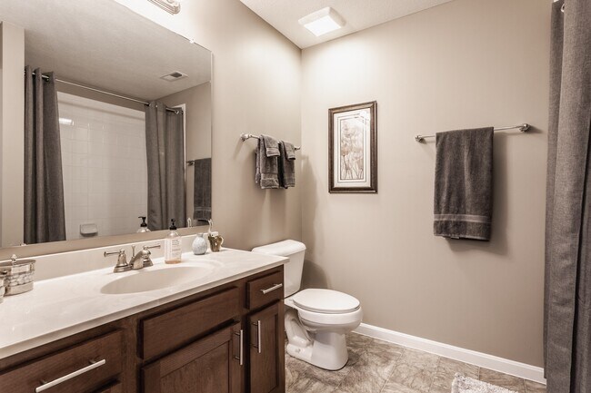 Ingrese a un baño bellamente diseñado con un tocador funcional, acabados elegantes y un ambiente luminoso y acogedor. - Wheaton Village Apartments