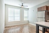 Located at 5567 Odana Rd in Madison, Wisconsin, this one-bedroom, one-bathroom unit offers a well-organized single-floor layout with a clean, contemporary design throughout. Light hardwood-style flooring flows seamlessly from room to room, creating a cohesive and bright aesthetic.

The kitchen is a standout feature, showcasing warm wood-tone cabinetry that extends to the ceiling, white quartz countertops, a geometric hexagonal tile backsplash, and a full suite of stainless steel appliances including a refrigerator, electric range, over-the-range microwave, and dishwasher. A freestanding island provides additional prep and dining space, while recessed lighting overhead ensures the area is well-lit.

The living and entry areas are open and airy, with large windows allowing natural light to fill the space. White panel doors and neutral gray walls throughout contribute to a modern, understated palette.

The bedroom is a comfortable size, featuring a bold dark teal accent wall, ceiling fan with integrated lighting, and a spacious closet with bifold doors and built-in shelving. The neutral tones of the remaining walls keep the room feeling fresh and versatile.

The bathroom is efficiently laid out with warm wood vanity cabinetry, a white countertop with an undermount sink, a large mirror, and light hardwood-style flooring that ties the space together. A separate area accommodates the shower, offering a practical and clean design.