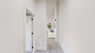 This thoughtfully designed one-bedroom, one-bathroom unit at 536–540 Central Ave in Newark offers a compact yet functional single-floor layout with modern finishes throughout. Light-toned, wood-look flooring flows consistently across the space, complementing the crisp white walls and creating a clean, cohesive aesthetic.

The kitchen is well-appointed with a two-tone cabinet design — glossy white upper cabinets contrast with wood-grain lower cabinets — paired with granite countertops, under-cabinet lighting, a stainless steel refrigerator, and a gas range. The layout maximizes efficiency without sacrificing style.

The living and dining area benefits from large black-framed windows that invite natural light and offer outdoor views of mature trees, lending a refreshing connection to the surroundings. The bedroom is a comfortable retreat featuring two sets of double closets with paneled doors and black hardware, providing ample storage. A large window frames greenery outside, filling the room with natural light.

The bathroom stands out with bold, multi-toned wood-effect tile work covering both the walls and floor in a striking horizontal stripe pattern. A modern floating vanity with black-accented fixtures and a window add both function and natural light to the space.

A hallway connects the rooms efficiently, completing this well-organized and stylishly finished home.