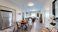 Located at 1901 Vine St in Kansas City, MO, this two-bedroom, two-bathroom residence offers a well-designed single-level layout with contemporary finishes throughout. The open-concept living and dining area is bright and welcoming, featuring wood-look plank flooring, neutral-toned walls, and large windows that invite natural light and city views. A glass door in the living room provides access to an outdoor area, adding to the airy feel of the space.

The kitchen is outfitted with light wood cabinetry, white tile backsplash, white quartz countertops, and a full suite of stainless steel appliances including a gas range, dishwasher, and full-size refrigerator. A dedicated dining area sits adjacent to the kitchen, offering a functional and cohesive space for everyday living.

The primary bedroom is a comfortable retreat with plush carpeting, a large window with city views, and direct access to a private bathroom. The en-suite bathroom features a wide vanity with light wood cabinetry, backlit mirrors, and a shower/tub combination. The second bathroom offers a walk-in shower and matching modern finishes. A dedicated closet provides additional storage. The overall design is clean and modern, suited for comfortable urban living in Kansas City.
