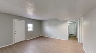Located at 6009 Bellaire Blvd in Houston, TX, this single-story home offers three bedrooms, four bathrooms, and a practical, well-organized layout. The spacious living room features light wood-look flooring, neutral gray walls, a textured ceiling, and a built-in shelving niche, creating an open and airy atmosphere with natural light filtering through the windows. The kitchen is equipped with gray cabinetry, granite-style countertops, a black refrigerator, electric range, and a sink beneath a window — offering a functional and clean workspace. Each of the three bedrooms is carpeted, with neutral tones, textured ceilings, and windows that bring in natural light and outdoor views. The primary bedroom provides a generous footprint with ample space for furnishings. The four bathrooms are consistently finished with updated gray vanities, granite-style countertops, large mirrors, and a combination of tiled tub-shower units — one featuring warm beige floor-to-ceiling tile and another with clean white tile surround. Three closets are distributed throughout the home, providing convenient storage. A connecting hallway ties all rooms together efficiently. The overall aesthetic is clean, neutral, and move-in ready.