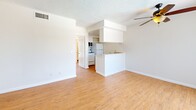 Located at 475 E Foothill Blvd in Pomona, California, this single-story, one-bedroom, one-bathroom residence offers a practical and well-organized layout. Throughout the unit, warm-toned hardwood-style flooring provides a cohesive and inviting aesthetic, complemented by crisp white walls and textured ceilings.

The living room serves as the heart of the home, featuring a ceiling fan with light fixture, a sliding glass door with vertical blinds that brings in natural light and provides access to an outdoor area, and ample wall space for flexible furniture arrangements. HVAC vents are conveniently positioned throughout to ensure comfortable climate control.

The kitchen is thoughtfully integrated into the living space via an open-concept design, anchored by a raised breakfast bar peninsula that defines the two areas. White appliances, overhead cabinetry, and a dedicated refrigerator nook make this kitchen both functional and space-efficient.

The bedroom is a comfortable, well-proportioned retreat with hardwood-style floors, a large window with vertical blinds admitting natural light, and direct access to the bathroom, providing added privacy and convenience. A closet with hanging space is accessible from the bedroom.

The bathroom features a tub and shower combination enclosed by sliding frosted glass doors with white subway tile surround, chrome fixtures, and a vanity with cabinet storage — all finished in a clean, neutral palette.