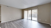 Located at 505 N Rock Rd in Wichita, Kansas, this single-floor unit offers a clean, modern interior with consistent light gray vinyl plank flooring throughout. The open living area is bright and welcoming, featuring neutral warm-toned walls, a textured ceiling, and a full-width sliding glass door dressed with vertical blinds that opens to an outdoor patio, allowing ample natural light to fill the space.

The kitchen is well-equipped with white cabinetry offering generous storage, light granite-style countertops, and black appliances including a refrigerator, electric range, and range hood. A large window in the kitchen area overlooks greenery outside, adding a pleasant natural view while cooking.

The bedrooms are spacious and neutrally appointed, with one featuring a mirrored sliding-door closet that enhances the sense of space. Additional rooms benefit from natural light via horizontal blinds-covered windows.

The bathrooms are updated with white cabinetry, granite-style countertops, dark hardware accents including towel bars and drawer pulls, and wood-look flooring that ties cohesively to the rest of the unit. The overall layout, as seen in the 3D floor plan, is well-organized and efficient, providing a comfortable and functional living environment.