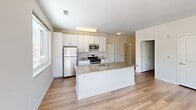 This contemporary 3-bedroom, 2-bathroom apartment in Norwalk, CT offers 1200 square feet of well-designed living space on a single floor. The open-concept layout seamlessly integrates the kitchen and living areas, creating a spacious feel. The kitchen is a highlight, featuring sleek white cabinetry, stainless steel appliances, and granite countertops with a convenient island.

Large windows throughout the apartment flood the rooms with natural light and provide picturesque views of the surrounding area, including winter scenes. The primary bedroom, measuring 240 square feet, offers ample space and includes an en-suite bathroom. Two additional bedrooms provide comfortable accommodations for family or guests.

The apartment boasts modern finishes, including wood-look flooring in the main living areas and plush carpeting in the bedrooms. Practical amenities include two closets for storage and a full-sized washer and dryer. The bathrooms feature clean, contemporary designs with neutral tiling and updated fixtures.

Located at 1 Glover 517 in Norwalk, this apartment combines urban convenience with a touch of suburban tranquility, making it an ideal residence for families or professionals seeking a stylish and comfortable living space.