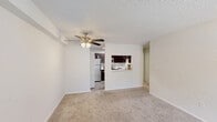 Located at 230 Pelham Rd in Greenville, SC, this one-bedroom, one-bathroom unit offers a well-organized, single-floor layout designed for comfortable everyday living. The open living area features soft wall-to-wall carpeting, a textured ceiling, and a ceiling fan with integrated lighting, creating a relaxed and functional atmosphere. A pass-through window connects the living space to the kitchen, which is thoughtfully designed with rich dark-brown cabinetry extending to the ceiling, light countertops, a double stainless steel sink, and stainless steel appliances including a range and over-the-range microwave. The kitchen's tile-style flooring adds a clean contrast to the warmer tones of the cabinetry. The bedroom is a comfortable size, also finished with plush carpet and a ceiling fan, and benefits from a window overlooking lush greenery, allowing natural light to fill the room. It features two doors — one leading to the hallway and another to a dedicated closet, providing ample storage. The bathroom is clean and straightforward, offering a full tub-shower combination with built-in shelving, finished in white with wood-look flooring. A hallway connects all rooms seamlessly, completing the efficient and practical floor plan of this Greenville residence.