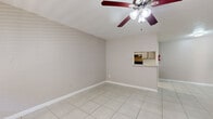 Located at 8323 Cinnamon Ln in Houston, TX, this single-story 2-bedroom, 1-bathroom home offers a clean, functional layout with consistent marble-look porcelain tile flooring running throughout every room. The combined living and dining area serves as the heart of the home, featuring warm neutral-toned walls, a ceiling fan with light fixture, and a pass-through window connecting to the kitchen, creating an open and connected feel. Natural light filters in through blinds-covered windows, enhancing the bright, airy atmosphere. The galley-style kitchen is efficiently designed with granite countertops, gray cabinetry, a decorative tile backsplash, and white appliances including a range and refrigerator, along with a pantry for added storage. Both bedrooms are comfortably sized, each equipped with ceiling fans and windows that bring in natural light. The primary bedroom is notably spacious and includes a closet. A dedicated laundry room with shelving provides added convenience. The bathroom features warm beige tile surrounding a tub-shower combination, a granite-topped vanity, and a large mirror. Three closets throughout the home offer ample storage. The overall aesthetic is clean, neutral, and move-in ready.