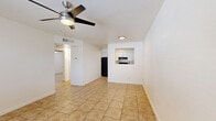 Located at 3055 N Flowing Wells Rd in Tucson, Arizona, this 2-bedroom, 1-bathroom residence offers a practical and comfortable single-story layout. Warm-toned ceramic tile flooring runs consistently throughout the entire home, lending a cohesive look to every room.

The open living area is anchored by a ceiling fan with a built-in light fixture and flows naturally toward the kitchen. The kitchen features white cabinetry, granite-style countertops, black appliances including a full-size refrigerator, and a convenient pass-through window that connects to the living space — ideal for easy interaction between rooms.

Both bedrooms are well-proportioned, each equipped with a ceiling fan and window fitted with blinds that allow for natural light and privacy. The primary bedroom offers generous closet storage with a sliding-door closet, while the second bedroom also includes a built-in closet with a hanging rod. A connecting hallway links the bedrooms to the rest of the home.

The bathroom is clean and functional, featuring a full tub and shower combination with a tile surround, a toilet, and a vanity with sink. Tile flooring continues here as well, maintaining the home's consistent aesthetic. Overall, the space presents a bright, neutral palette that is move-in ready.
