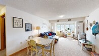 Located at 2615 University Ave SE in Minneapolis, Minnesota, this single-floor unit offers a practical and well-organized layout suited for everyday living. The combined living and dining area serves as the heart of the home, featuring carpet flooring, a textured ceiling, and large windows that allow natural light to fill the space and offer views of the surrounding neighborhood. The open arrangement comfortably accommodates both a dining table and a seating area, creating a versatile shared space.

The kitchen is positioned adjacent to the main living area and is equipped with warm wood-toned cabinetry, a full suite of white appliances including a refrigerator, range, and built-in microwave, and durable tile-style flooring. Ample cabinet and counter space make this kitchen functional for daily meal preparation.

The unit includes two bedrooms, each with carpet flooring, textured ceilings, and closet access. One bedroom features a window with natural light and sufficient space for study and sleeping areas. A hallway connects the bedrooms to the rest of the unit, providing a clear and efficient flow throughout.

Two full bathrooms serve the unit, each featuring a tub-shower combination with a curtain, a vanity with storage, and tile-style flooring. The overall layout is straightforward and functional, making this unit a practical option in the University Avenue corridor of Minneapolis.