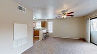 This single-floor, 1-bedroom, 1-bathroom unit offers a practical and comfortable layout designed to maximize every square foot. The open living area is finished with plush wall-to-wall carpeting and features a ceiling fan with integrated lighting, a textured ceiling, and a built-in HVAC unit, creating a cozy and climate-controlled environment. Natural light filters in through multiple windows, keeping the space bright and welcoming.

The kitchen flows seamlessly from the living area and is equipped with warm wood-toned cabinetry, a full suite of white appliances including a refrigerator and electric range, and durable laminate wood flooring. A peninsula counter with bar seating provides a casual dining option and defines the boundary between the kitchen and living space.

The bedroom is a generously sized retreat, also carpeted, with a ceiling fan, a large window for natural light, and two mirrored sliding-door closets offering abundant storage. Direct access to the bathroom is conveniently located off the bedroom.

The bathroom features wood-look flooring, a wood-toned vanity with countertop storage, and a full-size soaking tub and shower combination with clean white tile surround. Throughout the unit, neutral tones and consistent finishes create a cohesive, move-in-ready atmosphere.