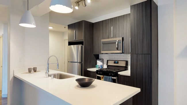 Cocina moderna con gabinetes de dos tonos y una isla grande. - Alister Sherman Oaks