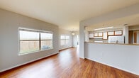 This single-story, 2-bedroom, 3-bathroom unit offers a practical and comfortable layout designed for everyday living. The open-concept living and dining area is bright and welcoming, featuring warm hardwood-style flooring and multiple windows that invite abundant natural light and views of the outdoor surroundings, including a fenced yard area. The space flows seamlessly into a well-equipped kitchen, which features a breakfast bar counter, warm-toned cabinetry with wood accents, white appliances including a range and refrigerator, and a skylight that further enhances the bright atmosphere.

The two bedrooms are carpeted for comfort, each offering a calm, neutral palette. The primary bedroom is generously sized and includes a ceiling fan and a walk-in closet with wire shelving. The secondary bedroom features a window with natural light. The unit includes three bathrooms, each featuring white tile tub-and-shower combinations and practical cabinetry.

The entry area transitions smoothly from tile to hardwood-style flooring, providing a clean and defined threshold. A private balcony extends the living space outdoors. Throughout the unit, neutral gray walls, clean white trim, and consistent flooring choices create a cohesive and move-in-ready aesthetic.