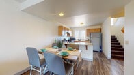Located at 19700 14 Mile Rd in Big Rapids, Michigan, this multi-floor residential space spans three levels connected by a wood-railed staircase, offering a functional and comfortable layout throughout. The main living area features durable wood-style flooring, neutral walls, and ample room for relaxation and entertaining. A well-appointed kitchen anchors the main floor, showcasing warm honey-toned cabinetry, granite-style countertops, a peninsula with bar seating, a stainless steel refrigerator, and an electric range — all complemented by a large vertical-blind window that fills the space with natural light. The adjacent dining area accommodates a full-sized table, creating a seamless flow between cooking and dining. Bedrooms are private and well-proportioned, each featuring wood-style flooring, windows with vertical blinds for natural light, and sufficient space for both sleeping and study areas. The bathroom includes a full tub-shower combination with clean, straightforward finishes. Throughout all three floors, the consistent use of light-toned walls and wood-style flooring creates a cohesive, easy-to-maintain aesthetic. The overall design prioritizes practicality and livability, making this a well-suited space for everyday residential use in the Big Rapids area.