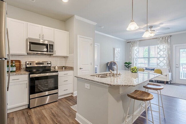 Experience the elegance of this modern kitchen, seamlessly connecting to a bright, airy living space. - Sanctuary at Powell Place