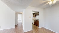 This 2-bedroom, 2-bathroom single-floor residence in El Paso, Texas, offers a practical and comfortable layout designed for everyday living. The main living area features warm wood-style flooring that flows through the open space, complemented by neutral white walls and a textured ceiling. Two windows allow natural light to fill the room, creating a bright and inviting atmosphere.

The kitchen is efficiently laid out with dark wood cabinetry, granite-style countertops, and white appliances, including a dishwasher and refrigerator. A separate door within the kitchen provides additional access to the unit.

A central hallway connects the bedrooms and bathrooms, offering a clear and organized floor plan. Both bedrooms are carpeted, providing a comfortable feel underfoot. The primary bedroom offers a generous footprint with wall sconce lighting, while the second bedroom features a window with blinds that allows for natural light. Each bedroom includes its own dedicated closet for ample storage.

The two bathrooms are finished with white square tile surround. One features a walk-in shower with chrome fixtures, while the other includes a full soaking tub with tiled surround. Together, these spaces provide functional and well-appointed bathing options for residents.