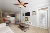 Located at 100 Ardsley Pl in Norcross, GA, this well-appointed 2-bedroom, 2-bathroom single-floor residence offers a thoughtfully designed open-concept layout. The combined living, dining, and kitchen area serves as the heart of the home, featuring plush carpeting, ceiling fans with light fixtures, and abundant natural light streaming through large windows with slatted blinds. A front entry door with transom window adds a welcoming touch.

The kitchen is equipped with rich dark cabinetry, granite countertops, black appliances including a range, dishwasher, and refrigerator, and wood-look flooring. A breakfast bar with barstool seating connects the kitchen seamlessly to the dining and living areas.

Both bedrooms are comfortably sized, carpeted, and filled with natural light from multiple windows. The primary bedroom offers ample space and ceiling fan. Each bathroom features dark wood vanity cabinetry, granite countertops, wood-look tile flooring, and well-lit mirrors.

Additional highlights include seven closets for generous storage, a pantry, a utility room, a hallway, and a private patio. The neutral gray color palette and consistent finishes throughout create a cohesive, modern ambiance.