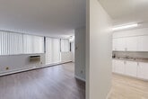 Located at 935 Dundas St E in Mississauga, this 2-bedroom, 1-bathroom unit is laid out efficiently across a single floor. Light wood-style flooring runs throughout the space, creating a clean and cohesive look from room to room. The open-concept living, dining, and kitchen area forms the heart of the unit. The living room is generously proportioned, featuring a ceiling fan, a wall-mounted air conditioning unit, and large windows dressed with vertical blinds that allow for ample natural light. The kitchen is well-equipped with white shaker-style cabinetry, ample upper and lower storage, a double sink, and white appliances including a stove and refrigerator. Textured ceilings are present throughout the unit. Both bedrooms offer a quiet, neutral setting with light-toned walls and light wood flooring. The primary bedroom is a comfortable size and includes a closet, while the second bedroom also features built-in closet space. The full bathroom includes a soaking tub and shower combination with white square tile surround. A dedicated hallway and closet provide additional storage. This unit offers a functional and well-maintained layout suited for everyday living in a convenient Mississauga location.