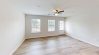 Located at 1375 Companion Ct in Sumter, South Carolina, this single-story, 2-bedroom, 2-bathroom home offers a well-organized layout designed for comfortable everyday living. The open kitchen and living room area serves as the heart of the home, featuring light wood-look LVP flooring, recessed lighting, and ceiling fans that promote airflow throughout. The kitchen is equipped with gray shaker-style cabinetry, white quartz countertops, stainless steel appliances including a range, microwave, and refrigerator, and a central island with a built-in sink and pendant lighting above — ideal for both meal preparation and casual dining. The living room benefits from multiple windows that invite natural light and provide outdoor views, with a ceiling fan adding to the airy feel. Both bedrooms are carpeted and include ceiling fans; the primary bedroom is generously sized and offers its own closet. The two bathrooms feature gray vanities with quartz countertops, large mirrors, and brushed nickel fixtures, with one bathroom including a tub/shower combo. A dedicated laundry area with wire shelving and washer/dryer hookups adds convenience. Two closets provide ample storage throughout the home.