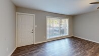 Located at 251 Gateway East Rd in Henrico, Virginia, this single-floor residence offers a thoughtfully updated interior with a cohesive, contemporary design throughout. Dark hardwood-style flooring runs consistently across the living areas, bedrooms, and kitchen, providing a warm and unified aesthetic against the cool gray walls and bright white trim.

The living area welcomes residents with a large picture window fitted with vertical blinds, allowing generous natural light to fill the space. A dedicated entry door provides direct access, adding a sense of privacy and convenience.

The kitchen is a standout feature, offering granite-style countertops, gray shaker cabinetry with modern hardware, and a full suite of stainless steel appliances including a refrigerator, range, microwave, and dishwasher. A peninsula island provides additional prep space and casual seating potential, seamlessly connecting the kitchen to the adjacent living area. A ceiling fan overhead adds comfort.

The bedrooms are well-sized, each equipped with a ceiling fan and light fixture. Natural light filters through window treatments, and closet storage is available. The bathrooms are finished in a clean, functional style, featuring white vanity cabinetry, granite-look countertops, and tub-shower combinations with bright overhead lighting and large mirrors.