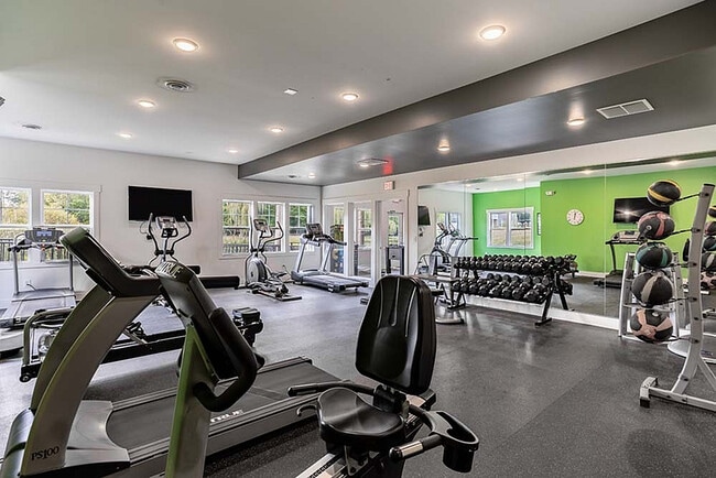 Large mirrors line the walls, creating a bright and motivating environment while helping residents perfect their form. - Aspen Lakes