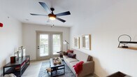 This single-floor residence offers a thoughtfully designed layout that balances functionality with contemporary style. The living area serves as the heart of the space, featuring light wood-style flooring, a ceiling fan, and French doors that open to a private balcony, allowing natural light to fill the room and providing outdoor views. Framed wall art and a neutral color palette contribute to a calm, inviting ambiance.

The kitchen is well-equipped with dark espresso cabinetry, granite countertops, a classic white subway tile backsplash, and stainless steel appliances including a range, microwave, and refrigerator. A peninsula with an undermount sink and pendant lighting above creates a functional eat-in space, while light wood-style flooring ties the kitchen seamlessly to the rest of the unit.

The primary bedroom features plush carpeting, a ceiling fan, and a window with outdoor views, creating a quiet and restful retreat. A second bedroom offers similar carpeting and a window with natural light. The full bathroom includes a granite-topped vanity, a large mirror, wood-style flooring, and a shower-tub combination, completing this well-rounded and comfortable living space.