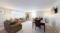 Located at 1603 Patricia Drive in Yeadon, PA, this one-bedroom, one-bathroom unit offers a well-organized single-floor layout designed for comfortable everyday living. The open-plan living and dining area forms the heart of the home, providing generous space for both relaxing and entertaining. Soft carpet underfoot and multiple windows dressed with sheer curtains and blinds allow natural light to fill the room throughout the day, creating a bright and welcoming ambiance. A dining area is seamlessly integrated into the living space, offering room for a full dining set. The kitchen features light-toned countertops, ample white cabinetry, a range, and hardwood-style flooring, providing a clean and functional workspace. The bedroom is a well-proportioned retreat finished with plush carpet, a natural-light window, and a warm-toned sliding closet door offering practical storage. Neutral wall tones throughout the unit contribute to a calm, cohesive aesthetic. A hallway connects the rooms efficiently, completing the thoughtful layout. This unit combines functional design with comfortable finishes in a convenient Yeadon location.