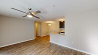 This single-floor, 2-bedroom, 1-bathroom residence offers a thoughtfully designed layout that maximizes functionality and comfort. The open-concept living and dining area features warm wood-look flooring and a ceiling fan with integrated lighting, creating a welcoming atmosphere. Large sliding glass doors and multiple windows allow abundant natural light to fill the space, offering views of the surrounding greenery.

The kitchen is positioned adjacent to the living area and features a peninsula with granite countertops, dark espresso cabinetry, black appliances, a built-in range, and a stainless steel sink with a modern faucet. Track lighting illuminates the galley-style workspace, which also provides direct access to the in-unit laundry room, equipped with a full-size washer and dryer along with overhead shelving for added storage.

The primary bedroom is generously sized, finished with plush carpeting, neutral-toned walls, and convenient access to the shared bathroom. The second bedroom also features carpet flooring and a window that brings in natural light. The full bathroom includes a granite-topped vanity with dark cabinetry, a tub-shower combination with tile surround, and wood-look flooring. A dedicated closet rounds out the home's practical storage solutions.