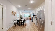 Located in Nashville's vibrant East Nashville neighborhood, this one-bedroom, one-bathroom residence offers a thoughtfully designed open-concept layout that seamlessly connects the kitchen, dining, and living areas. Light-toned hardwood floors run throughout, complementing the crisp white walls and recessed lighting that keep the space feeling bright and airy.

The kitchen is outfitted with white shaker-style cabinetry, granite countertops, and a full suite of stainless steel appliances, including a refrigerator, range, microwave, and dishwasher. A dedicated dining area sits adjacent to the kitchen, providing a natural flow for everyday living and entertaining.

The living room benefits from large windows that invite abundant natural light and offer views of the surrounding neighborhood. The bedroom is a comfortable retreat featuring a sizable window, plush carpeting, a walk-in closet with wire shelving, and direct access to the rest of the unit.

The bathroom is finished with a white shaker vanity, granite countertop, a walk-in tile shower, and hardwood-style flooring. A dedicated laundry area rounds out the unit's practical amenities. Clean lines, neutral tones, and modern finishes throughout create a cohesive and welcoming atmosphere.
