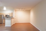 Located at 190 Ryland St in San Jose, California, this single-floor residence offers a well-appointed layout with a cohesive blend of practical finishes and functional design. The living area features warm hardwood flooring and is illuminated by track lighting, creating a bright and inviting atmosphere. Built-in shelving along one wall provides convenient storage and display space, while a peninsula with a granite-style countertop seamlessly connects the living area to the kitchen.

The kitchen is equipped with stainless steel appliances, including a refrigerator, electric range, over-the-range microwave, and dishwasher. Light wood cabinetry offers ample storage, and the double-basin sink is set beneath additional upper cabinets, making the space both efficient and practical.

The bedroom is finished with plush carpeting and features sliding glass doors that open to a private balcony overlooking a landscaped courtyard with mature trees, providing a serene outdoor retreat. The bathroom includes a full soaking tub and shower combination with chrome fixtures and a safety grab bar.

A sliding mirrored closet and central HVAC vents are also present throughout the unit, contributing to the overall comfort and functionality of this well-designed single-floor residence in the heart of San Jose.