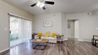 This well-designed one-bedroom, one-bathroom unit in Round Rock, Texas offers a functional and comfortable layout across a single floor. The open living room serves as the heart of the space, featuring durable wood-style flooring, neutral gray walls, and a ceiling fan with light fixture. Vertical blinds frame a sliding glass door that fills the room with natural light and provides outdoor views. The galley-style kitchen is efficiently organized with gray cabinetry, light countertops, a stainless steel sink, and white appliances including a refrigerator and range. A louvered bifold door leads to an in-unit laundry closet, adding everyday convenience. The bedroom is carpeted for comfort, bathed in natural light from a window with outdoor views, and includes a ceiling fan overhead. The bathroom features wood-style flooring, a gray vanity with a light stone-style countertop, and a full shower-tub combination. A dedicated closet and hallway complete the layout, providing practical storage. The unit's consistent neutral color palette and cohesive design elements create a clean, modern ambiance throughout.