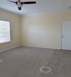 This well-designed 1010 square foot apartment offers a comfortable living space with two bedrooms and two bathrooms. The open-concept layout seamlessly connects the living room and kitchen, creating a spacious feel. The kitchen boasts modern appliances, including a black refrigerator and stove, complemented by warm wooden cabinetry and granite countertops. Both bedrooms are generously sized, with the primary bedroom measuring 200 square feet. Each room features plush carpeting and large windows that allow natural light to flood the space. The bathrooms are equipped with granite vanity tops and tiled shower/tub combinations. Throughout the apartment, you'll find ample storage solutions, including walk-in closets with wire shelving. The neutral color palette, featuring soft beige walls and white trim, provides a blank canvas for personalization. Ceiling fans in the bedrooms and living area ensure comfort year-round. Located in Sarasota, Florida, this apartment combines modern amenities with a practical layout, making it an ideal home for those seeking a contemporary living space.
