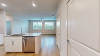 Located at 11305 Grant Rd in Houston, TX, this well-appointed single-story, 2-bedroom, 2-bathroom home offers a clean, modern aesthetic throughout. Light wood-tone flooring flows seamlessly across the entire living space, creating a warm and cohesive feel. The open kitchen is a standout feature, showcasing crisp white shaker cabinetry, granite-style countertops, a subway tile backsplash, and stainless steel appliances including a refrigerator, range, and microwave. A kitchen island provides additional prep and serving space. The combined kitchen and living area creates an open, functional layout ideal for everyday living. Both bedrooms are bright and airy, each equipped with a ceiling fan and windows dressed with horizontal blinds that frame views of the surrounding greenery. The spacious primary bedroom offers generous proportions and connects to dedicated closet space. Each of the two full bathrooms features white cabinetry with granite countertops, a tub-shower combination with floor-to-ceiling marble-look tile surround, and wood-tone flooring. Both bedrooms are complemented by walk-in closets outfitted with wire shelving systems, maximizing storage efficiency. The home's neutral palette and consistent finishes throughout contribute to a light, clean, and move-in-ready atmosphere.