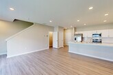 Located on NW Linosa Dr in Waukee, Iowa, this two-story home offers a thoughtfully designed layout across two floors. The main level features an open-concept kitchen and living area finished with light wood-tone luxury vinyl plank flooring and recessed lighting throughout. The kitchen is equipped with white shaker cabinetry, a large center island with a built-in sink and dishwasher, white quartz countertops, and a full suite of stainless steel appliances including a French door refrigerator, range, and microwave. The living area extends from the kitchen, offering natural light through windows and sliding glass door access to the exterior. A half bathroom is conveniently located on the main level. The attached garage features a concrete floor and an automatic opener. Upstairs, the home includes three bedrooms, three additional bathrooms, and a dedicated laundry room with a full-size washer and dryer. The generously sized primary bedroom is complemented by a walk-in closet with wire shelving systems. Bedrooms are finished with plush carpeting, while bathrooms continue the light wood-tone flooring. Neutral warm-gray walls throughout the home create a clean and cohesive aesthetic well-suited for modern living.