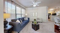 Located at 535 Brookwood Point Pl in Mauldin, SC, this well-appointed 2-bedroom, 3-bathroom single-floor residence offers a thoughtfully designed layout with comfortable living spaces throughout. The galley-style kitchen features light wood cabinetry, black appliances including a refrigerator, range, and built-in microwave, complemented by hardwood-style flooring and pendant lighting. A built-in desk nook adds a functional touch. The kitchen opens toward a carpeted living room adorned with crown molding, a ceiling fan, and large windows that invite abundant natural light and outdoor views of lush greenery. A separate sunlit sitting area with expansive windows further enhances the sense of openness. Both bedrooms are carpeted and feature ceiling fans, with the primary bedroom offering a generous footprint, an accent wall, and outdoor views. The three bathrooms are clean and functional, each featuring tub-shower combinations, warm wood vanities, and hardwood-style flooring. A dedicated laundry room houses a full-size washer and dryer with built-in shelving above. Two closets and a hallway round out the efficient floor plan, making this residence both practical and inviting for everyday living.